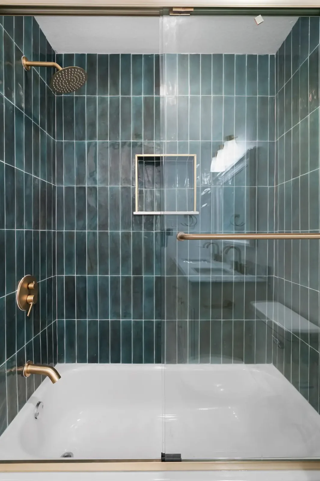 Tub-shower finished in vertical green gloss tile with a brass rain head and a recessed niche &mdash; Bremner remodel in Austin by Bailey & Bear Construction