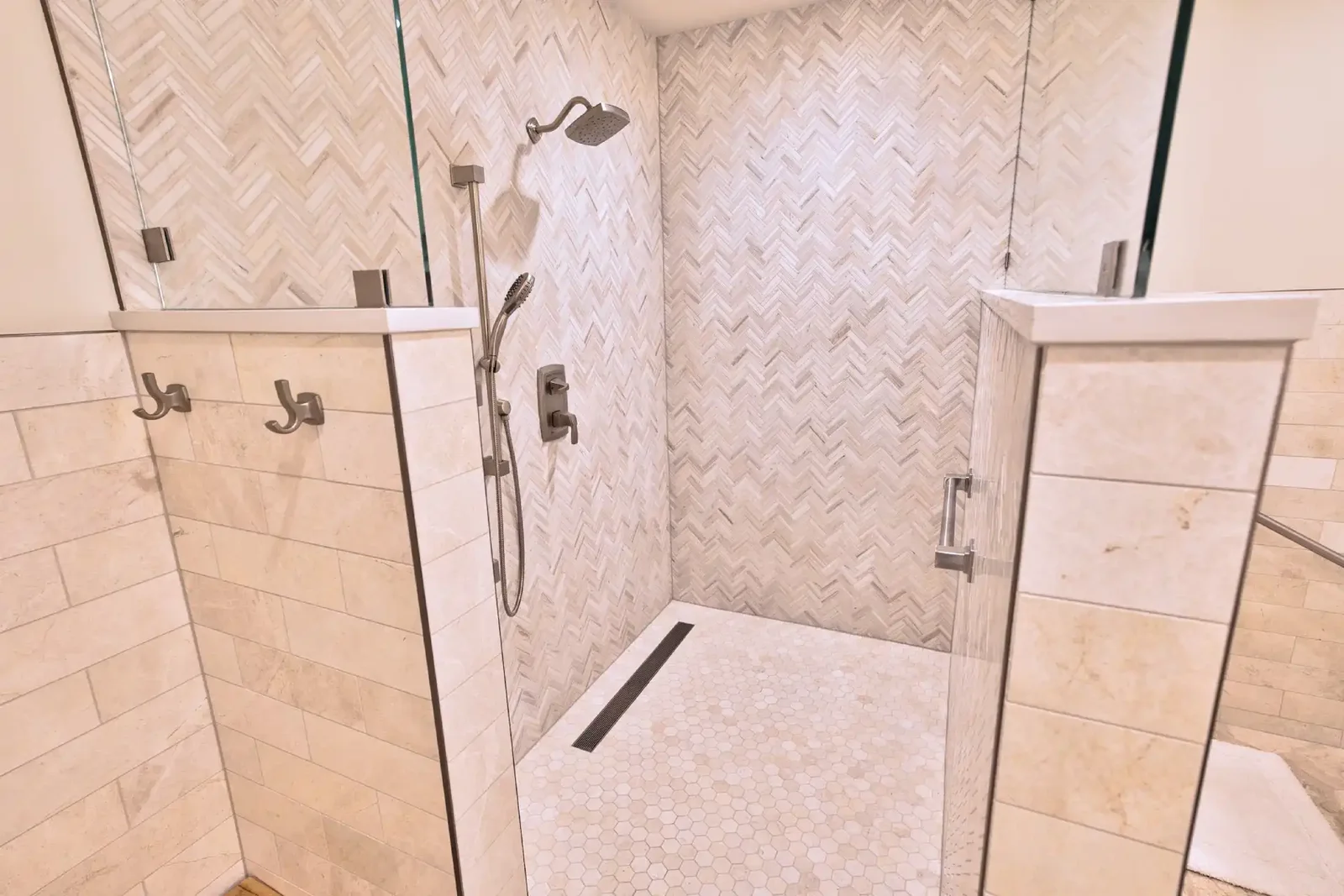 Curbless walk-in shower with herringbone stone walls, hexagon mosaic floor and a linear drain &mdash; East Avenue remodel in Austin by Bailey & Bear Construction